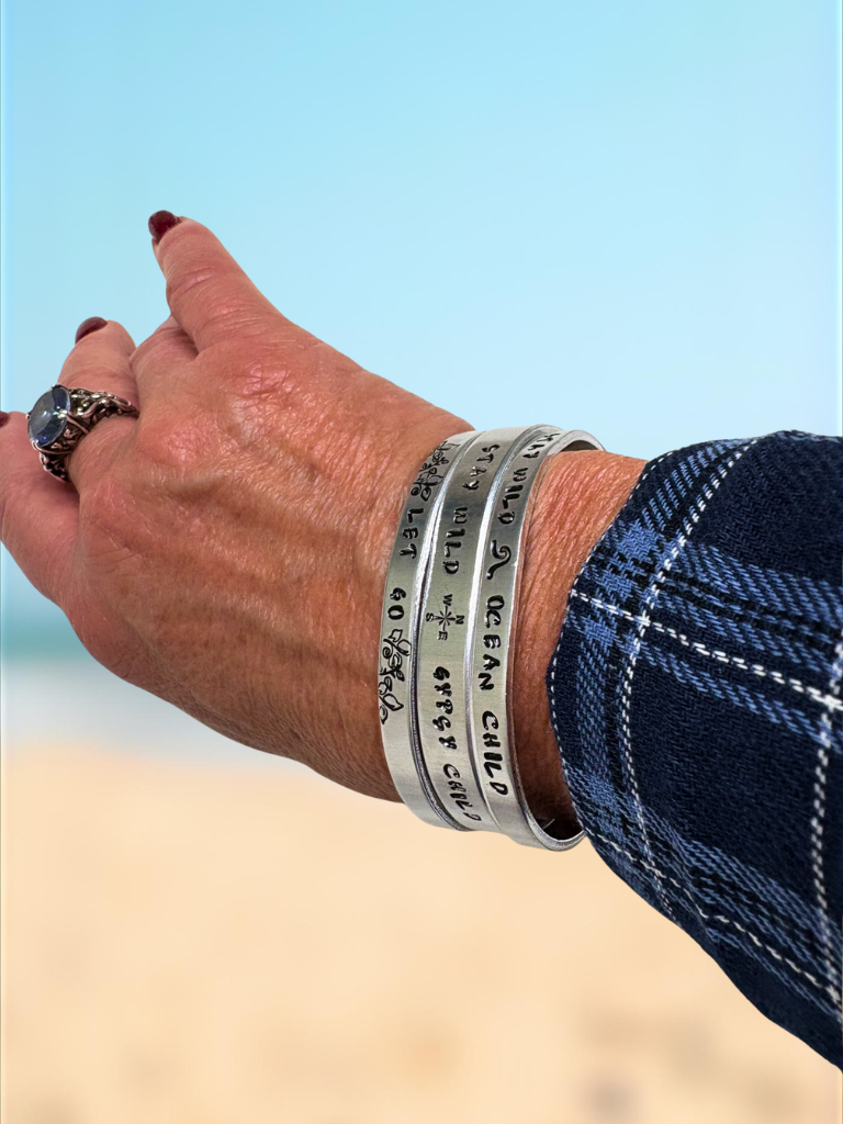 Close-up of a person's wrist wearing all 3 style bracelets.  