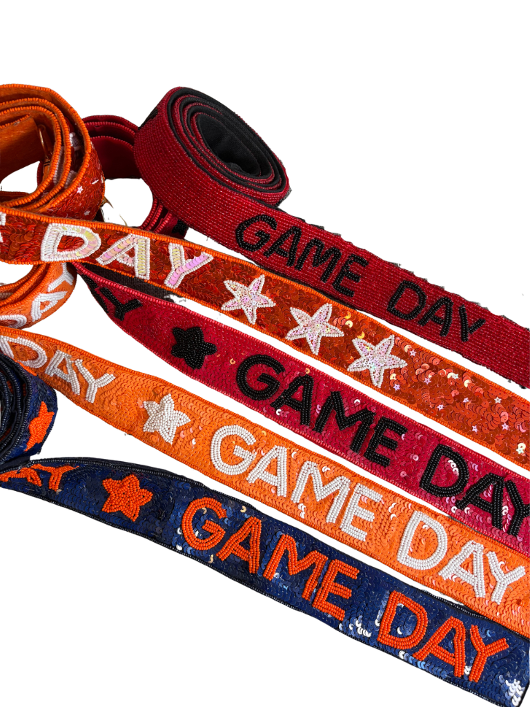 5 different Options of straps, rolled and laid-out fabric game day ribbons in navy blue, orange, red, and dark red, each printed with 'GAME DAY' and stars on a white background.