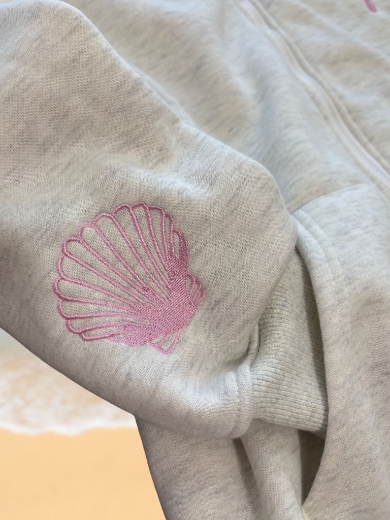 Coastal Bloom Hibiscus Embroidered Zip-Up Ladies Hoodie, Close Up, Shows Shell on the Sleeve.