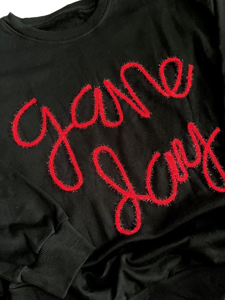 Black Game Day Sweatshirt with Red Tinsel Yarn Detail Close Up