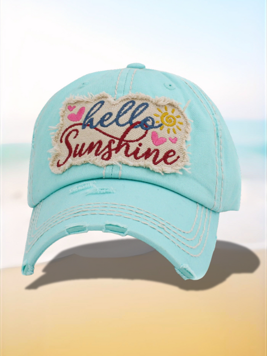 Light blue cap with 'hello sunshine' patch on a beach background