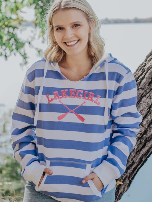 Woman wearing a blue and white striped hoodie with 'Lakegirl' text and oar design, standing outdoors.